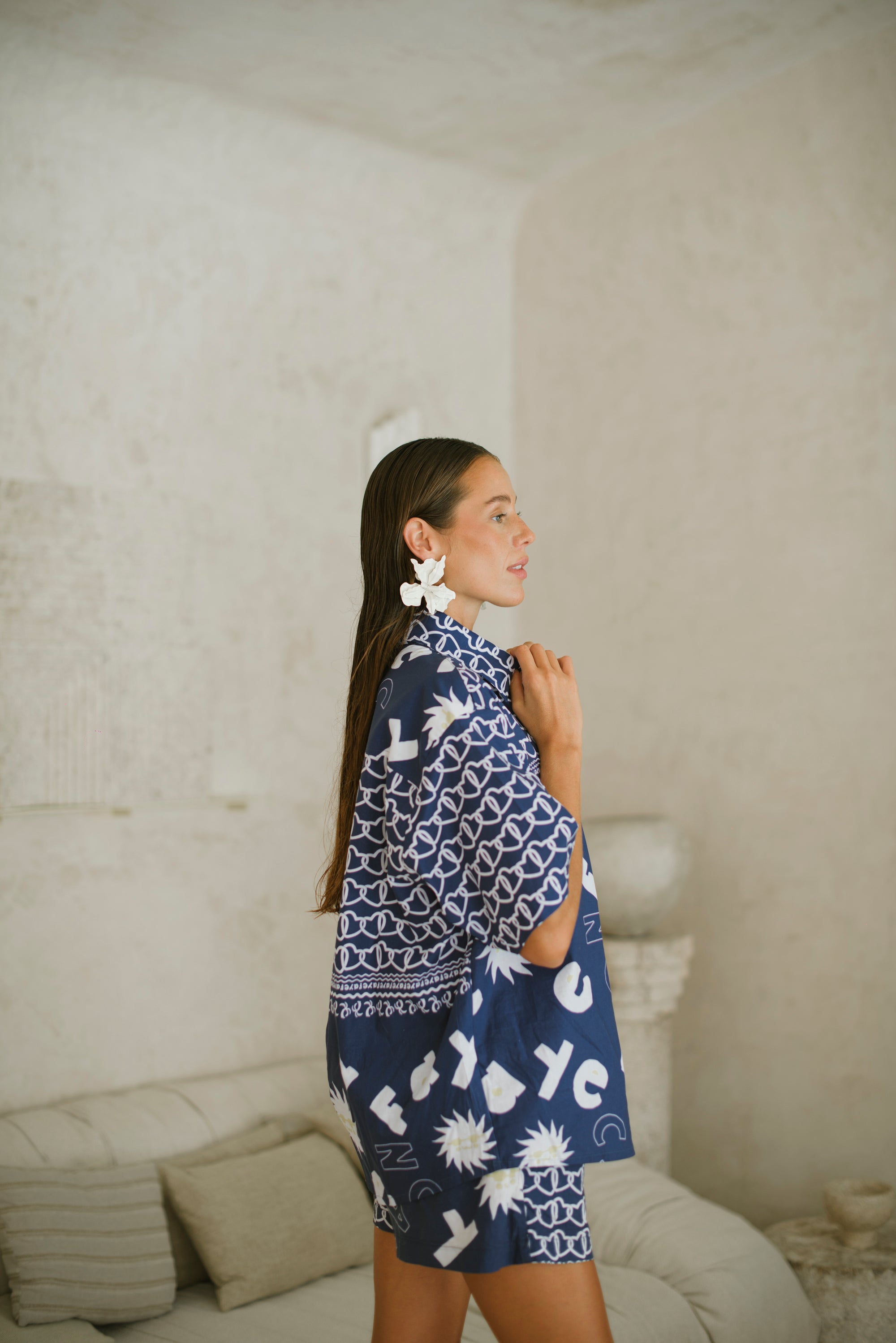 Woman wearing a blue patterned shirt in a neutral room
