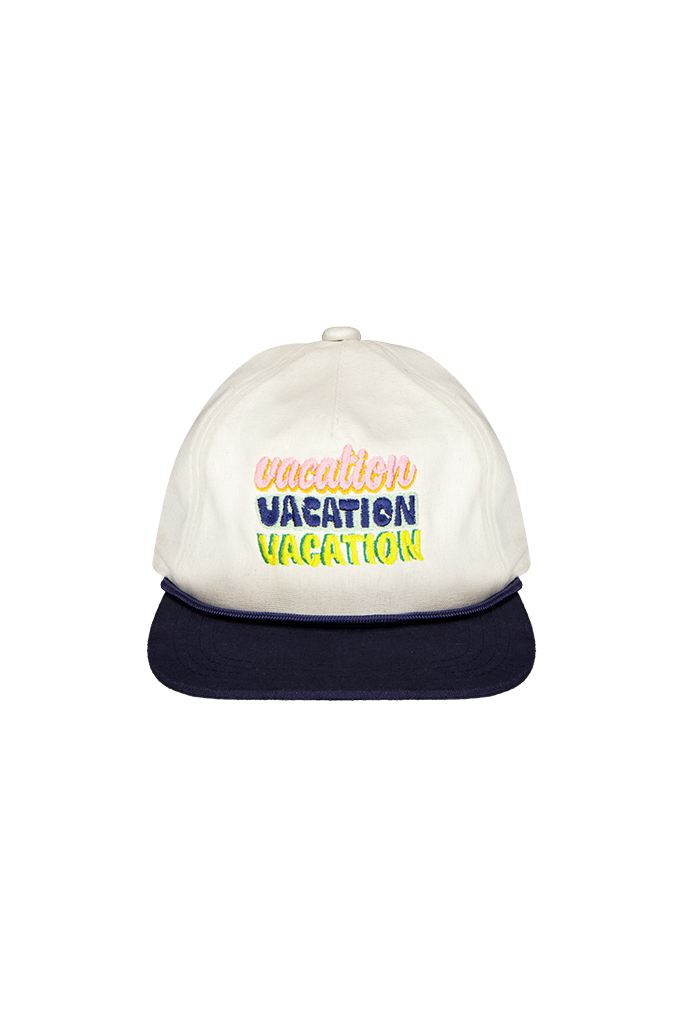 A white snapback cap with a dark navy blue flat brim, featuring the text 'vacation VACATION VACATION' embroidered on the front in pastel pink, blue, and yellow-green.
