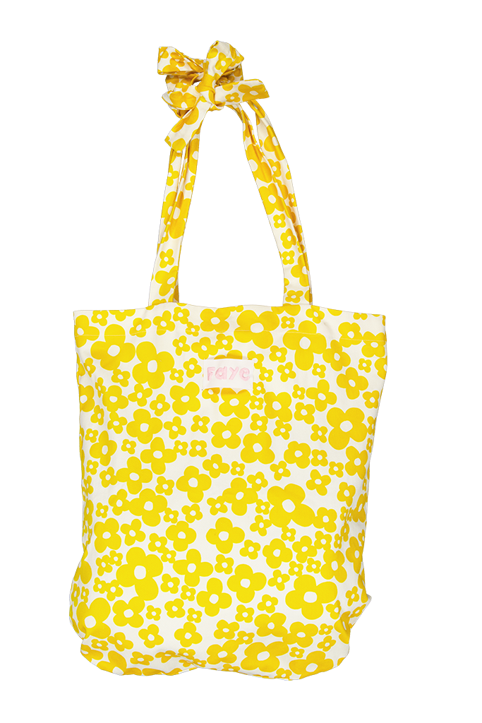 A yellow and white floral tote bag with matching fabric shoulder straps tied in a bow at the top, shown against a plain white background.